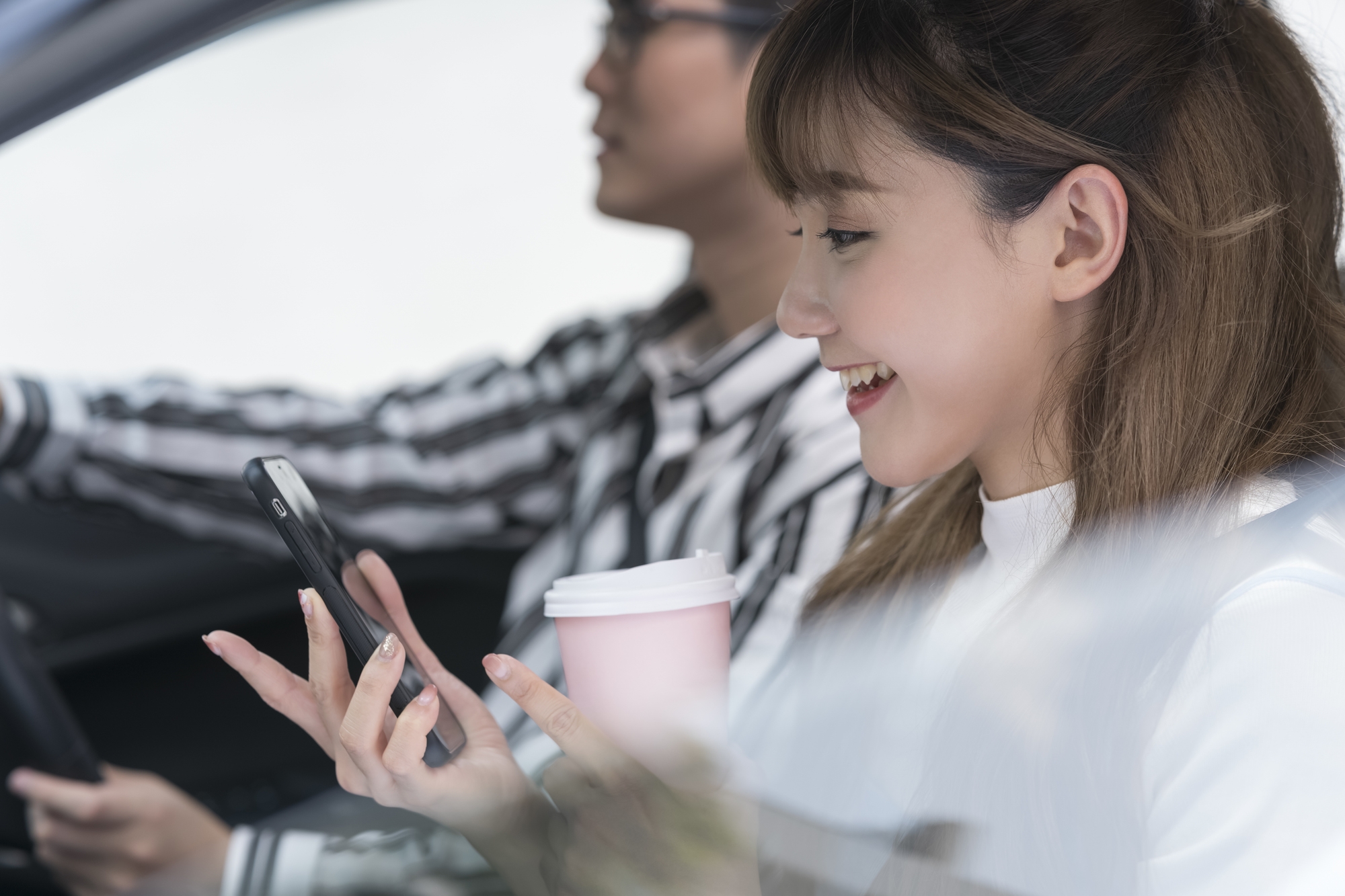 車内でスマホを操作する彼女